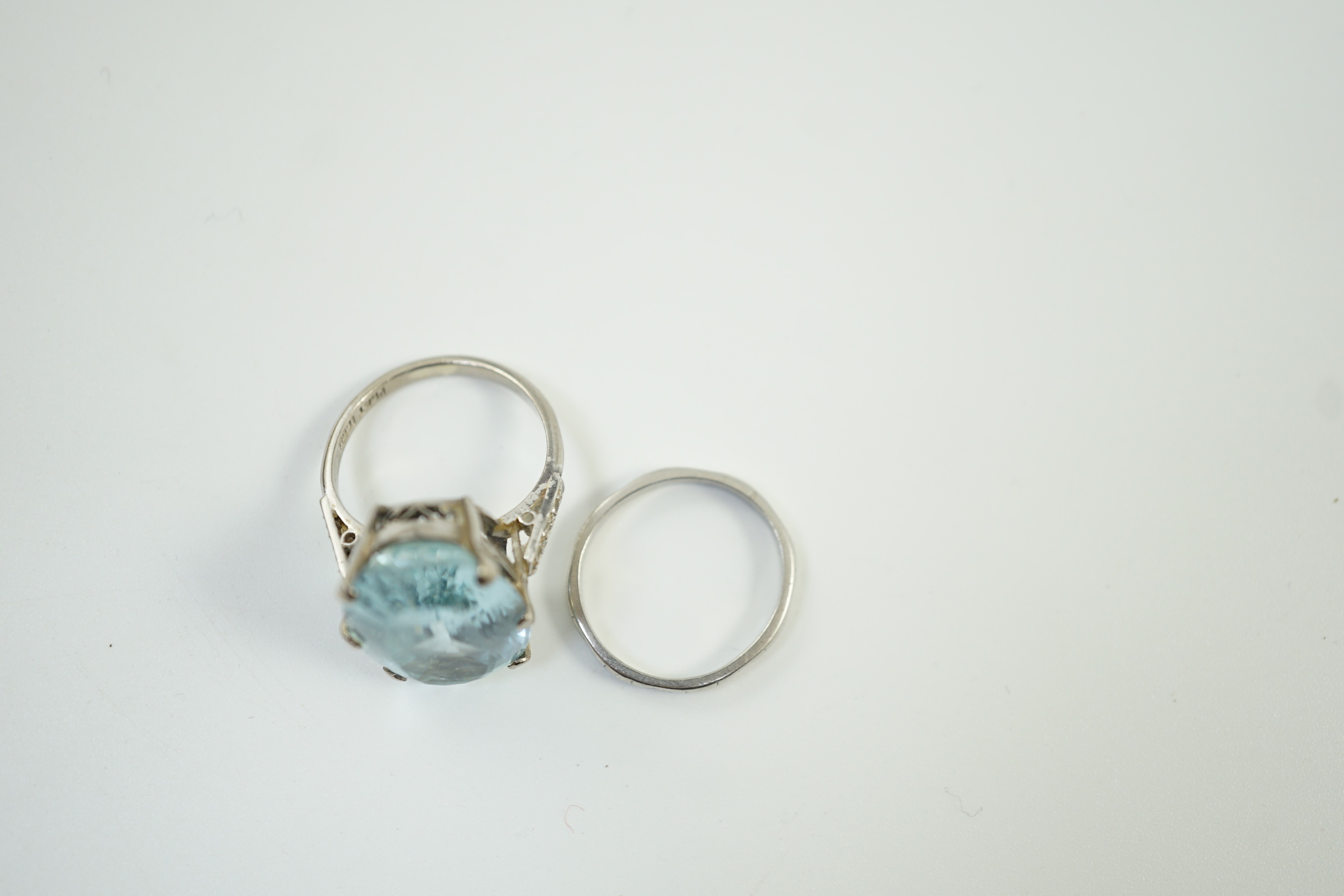An 18ct, plat and single stone oval cut aquamarine set ring, with diamond chip set shoulders, size K, gross weight 7 grams, together with a white metal, stamped platinum, wedding band, size I, 2.8 grams.
